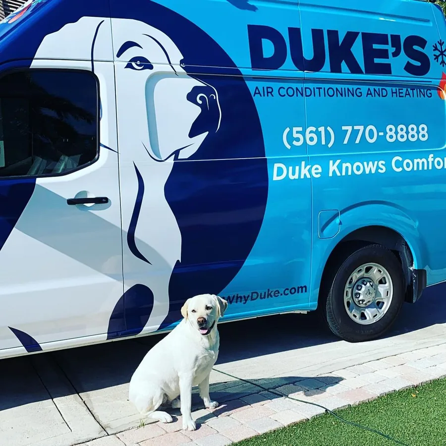 Duke the yellow Labrador sitting beside a Duke's Air Conditioning and Heating van