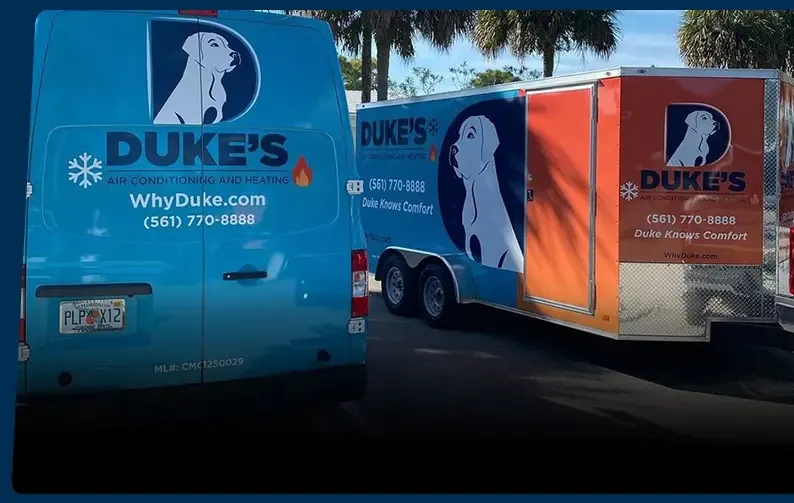 Duke's service van and branded equipment trailer parked under palm trees