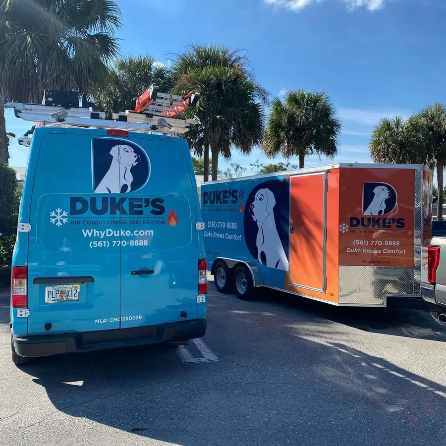 Duke's van and equipment trailer parked under palm trees