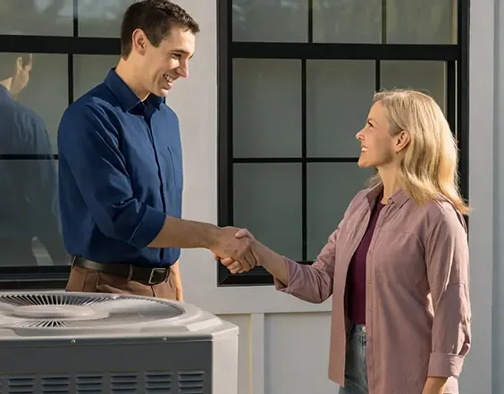 Duke's team member shaking hands with a homeowner beside a newly installed air conditioning unit