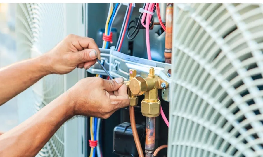 Duke's technician repairing refrigerant lines on an outdoor air conditioning condenser