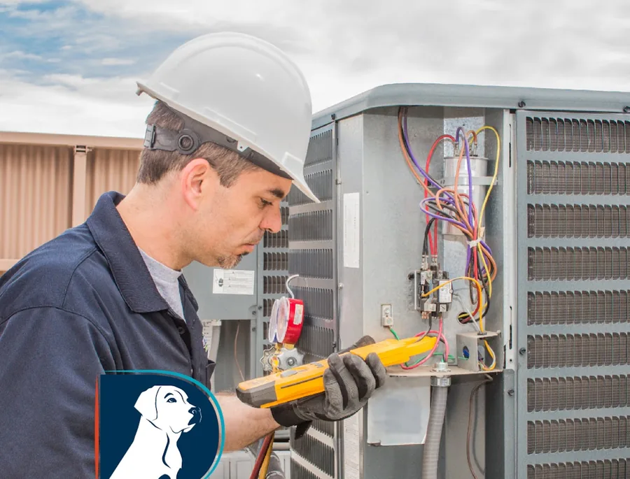 Duke's technician in a hard hat testing an electrical panel on a commercial HVAC unit