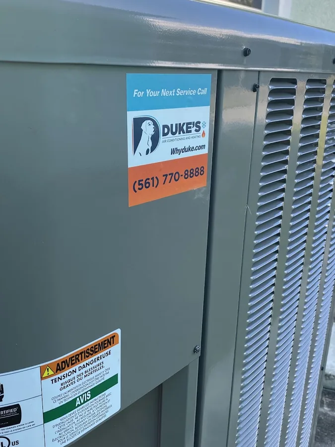 Air conditioning condenser with a Duke's Air Conditioning and Heating service sticker